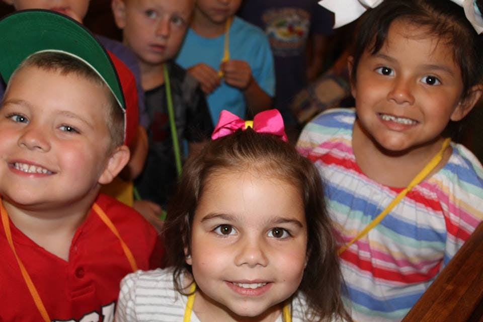 Three children smiling at the camera