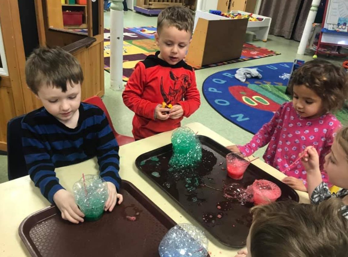 Children doing a science experiment with colorful bubbling liquids