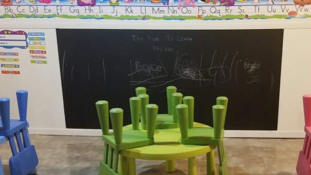 Classroom with small green table and chairs, and a chalkboard