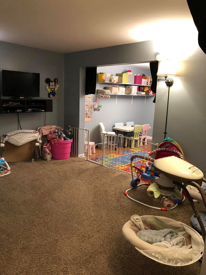 Living room with a playpen, baby swing, and television