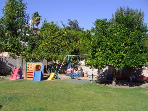 Playground with slides, swings, and play structure on grass