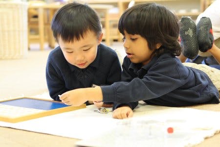 Two children on the floor looking at an object