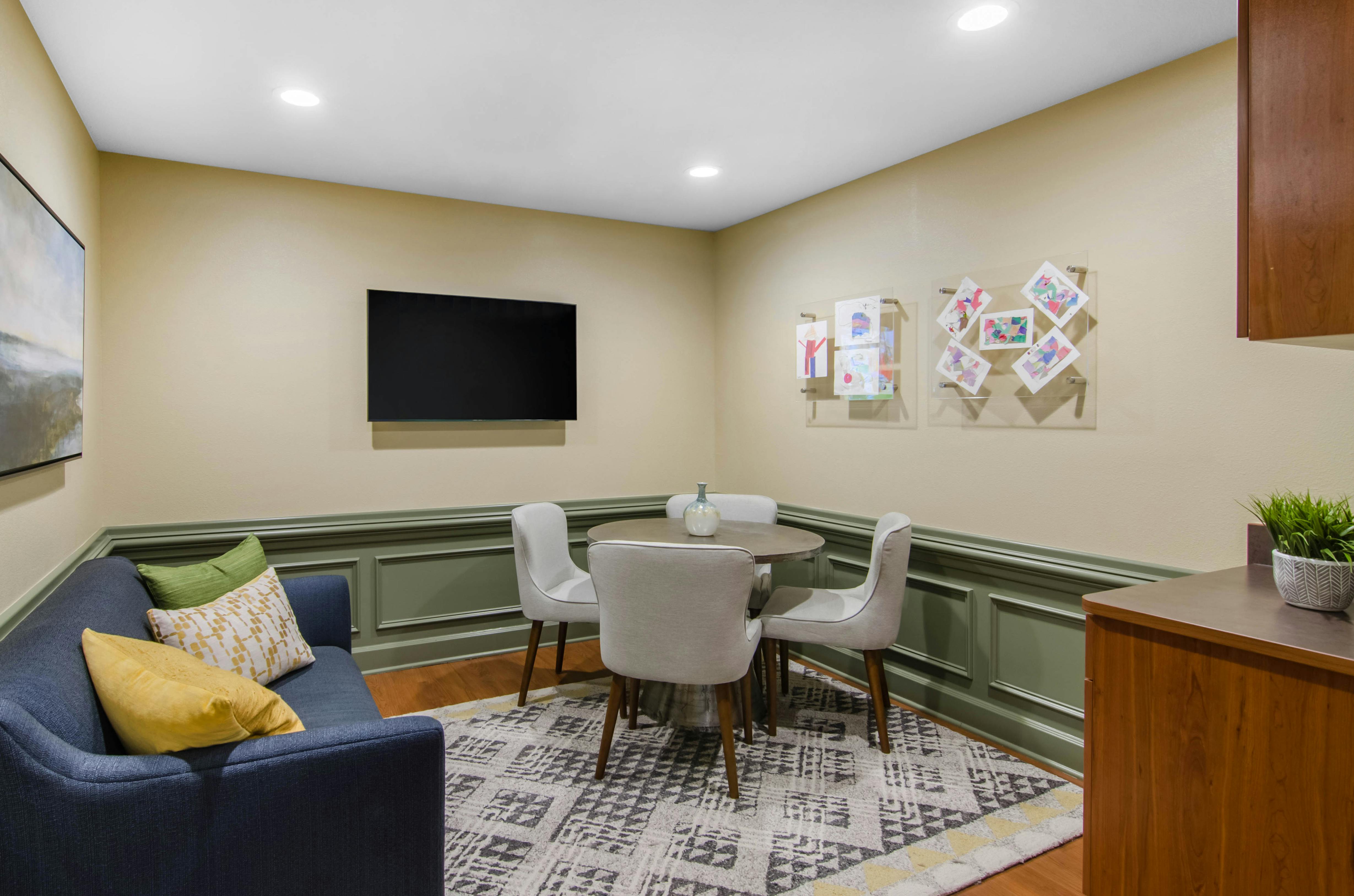 Lounge area with a blue sofa, round dining table, and four chairs