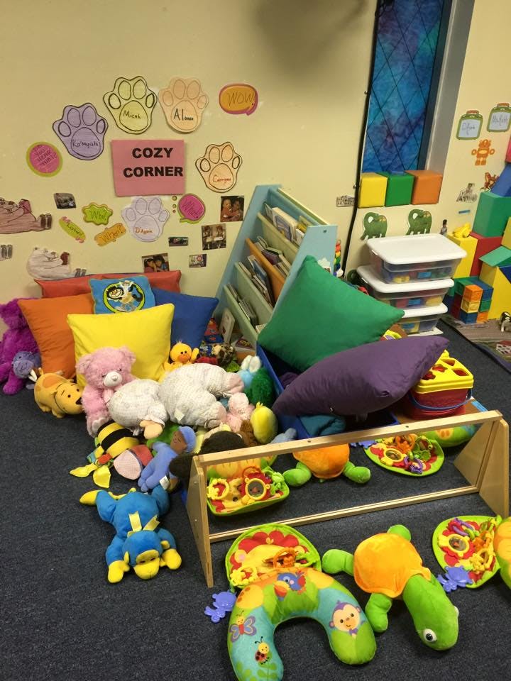 A cozy corner in a classroom with pillows, stuffed animals, and toys