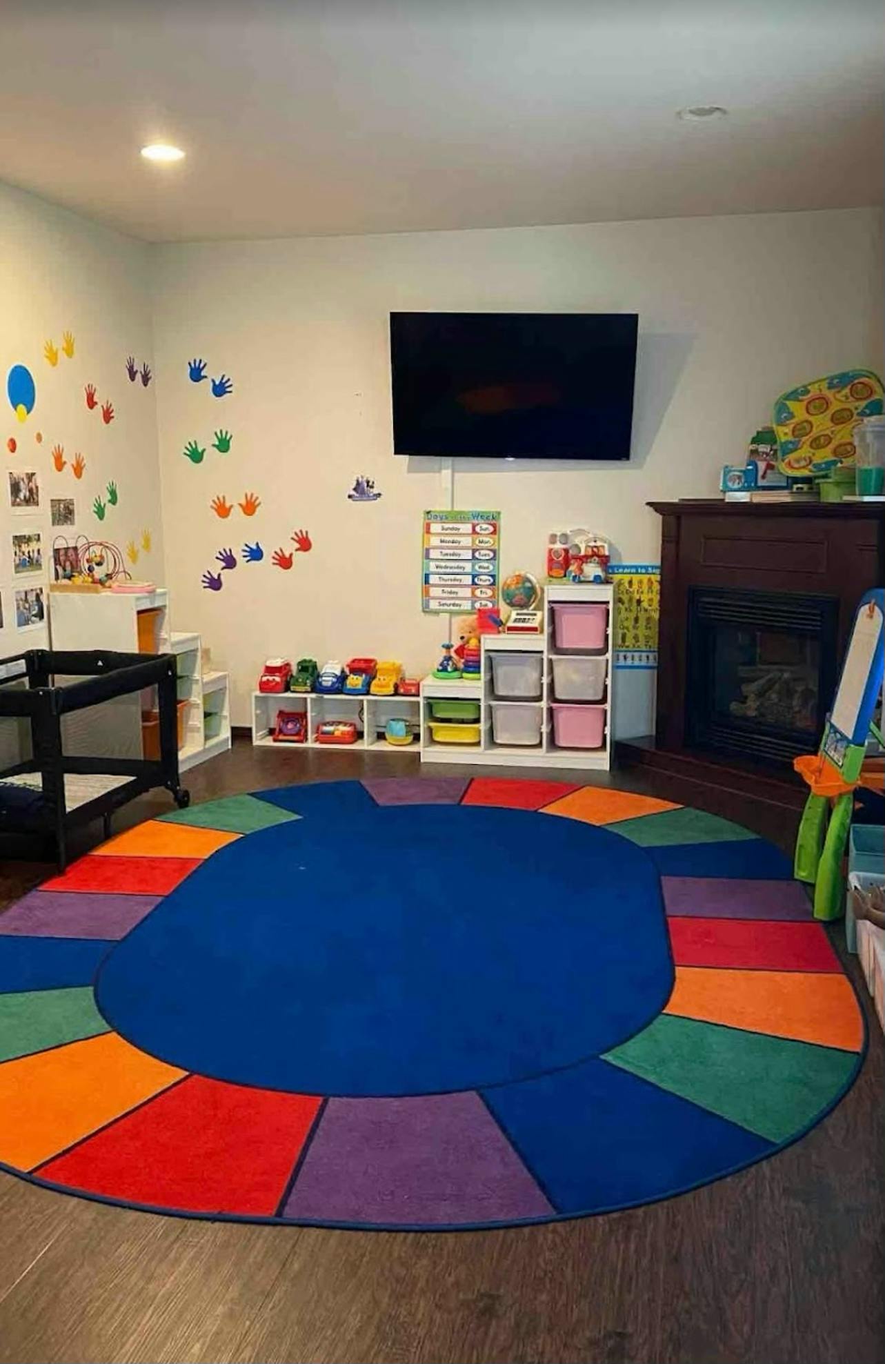 Children's playroom with a colorful rug, toys, and a crib