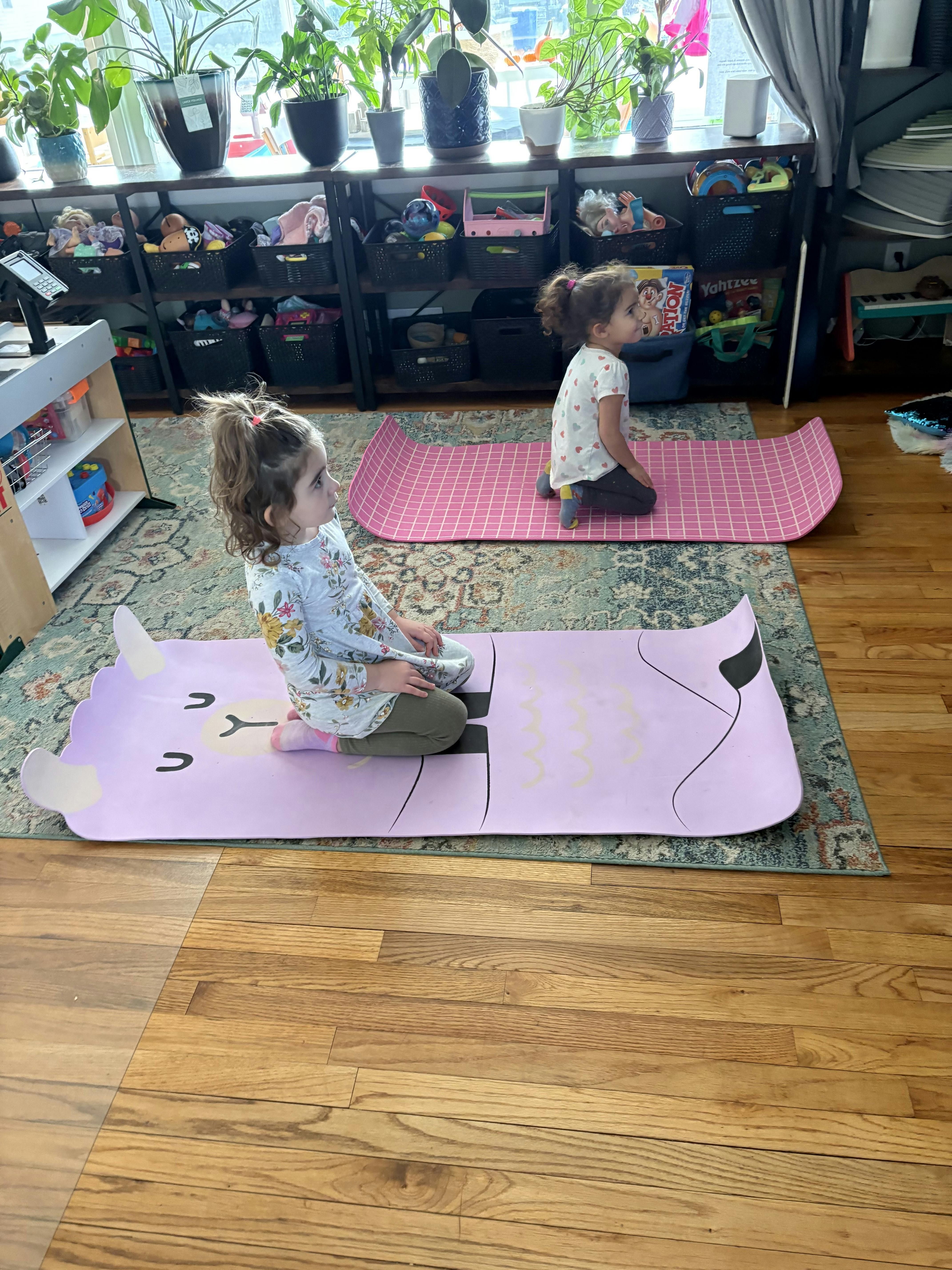 Two children kneeling on yoga mats