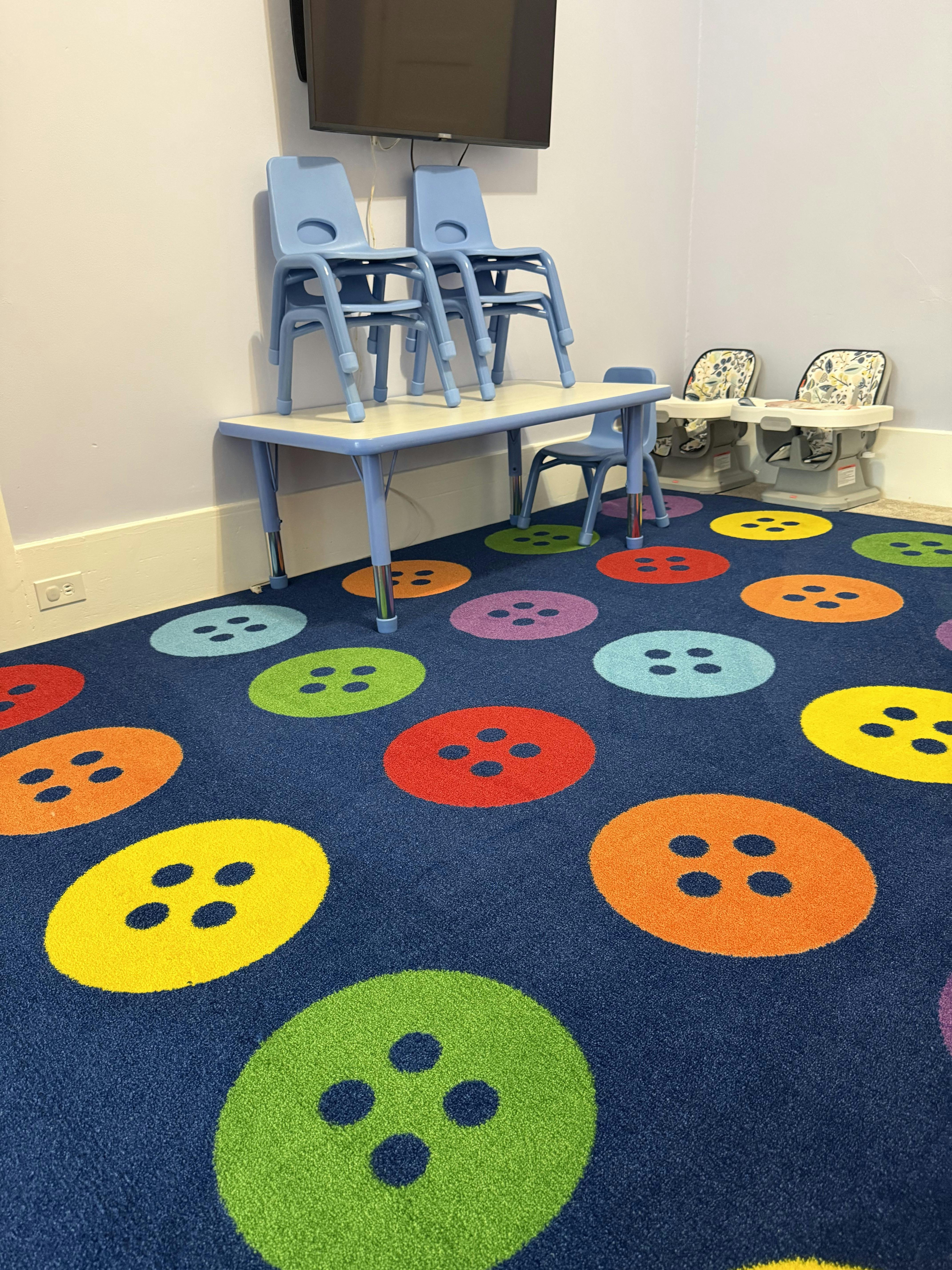 Children's table and chairs in a room with button-patterned carpet