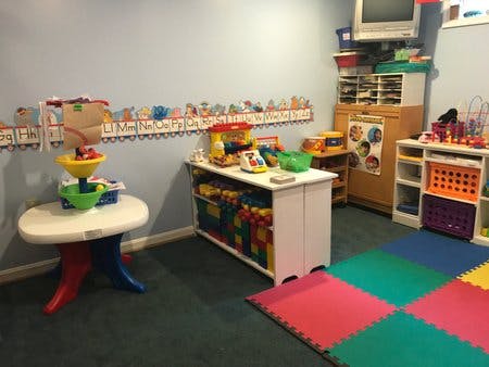 Playroom with toys, storage, and colorful floor mats