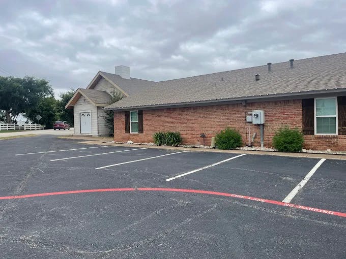 Building with brick facade and parking lot