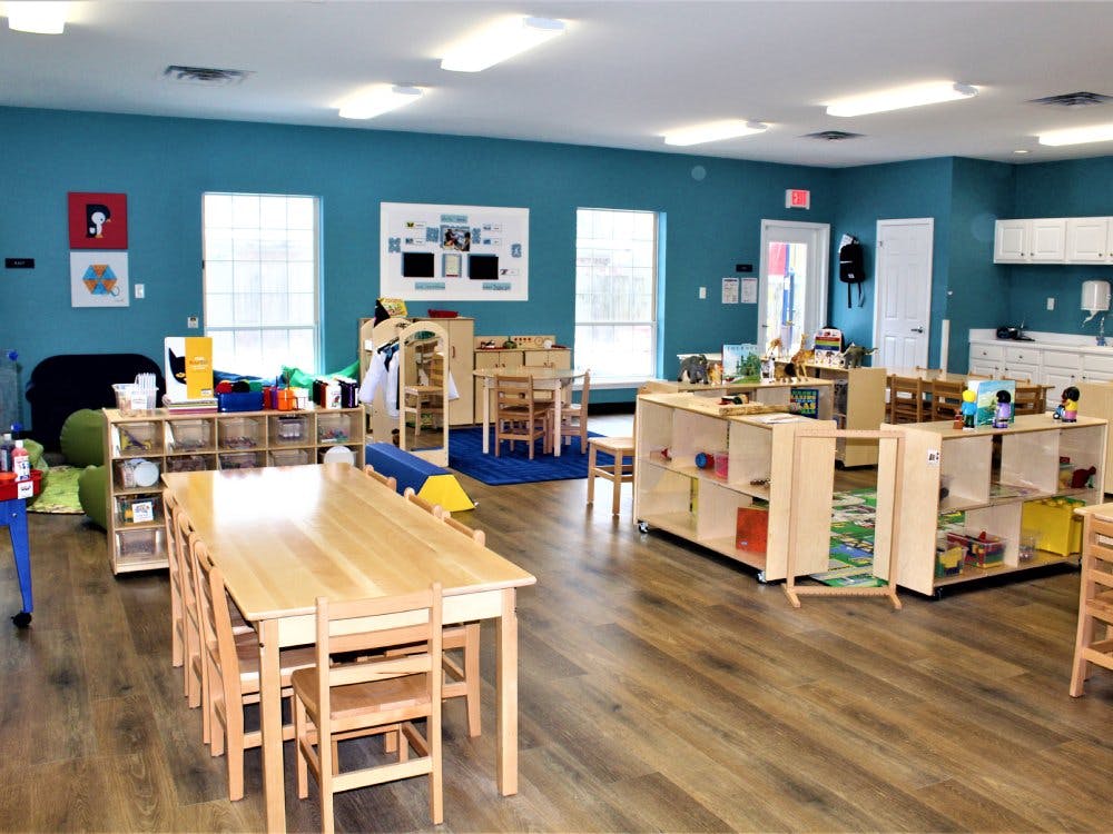 Classroom with wooden tables, chairs, and shelves