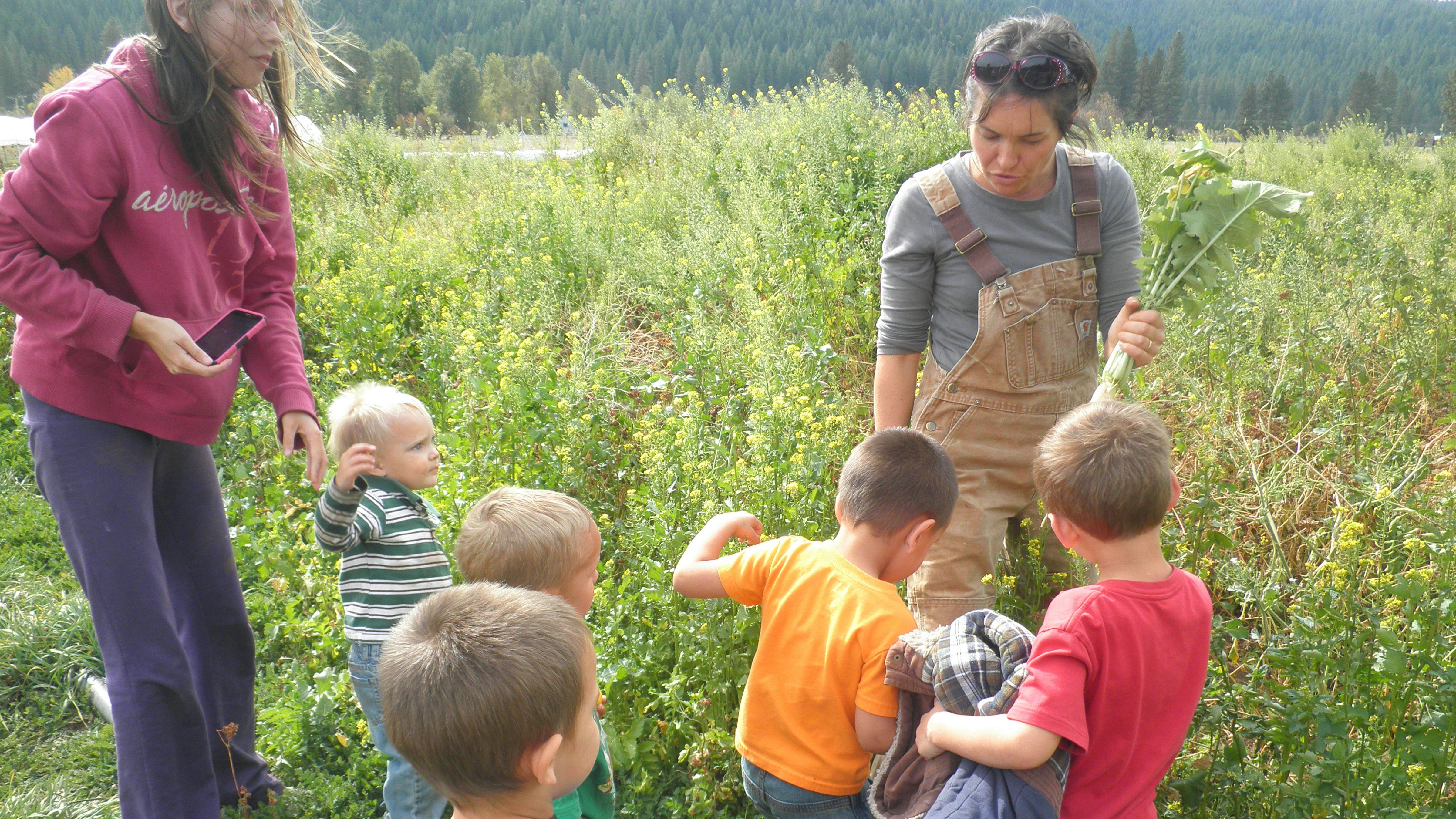 Two people and multiple children in a field