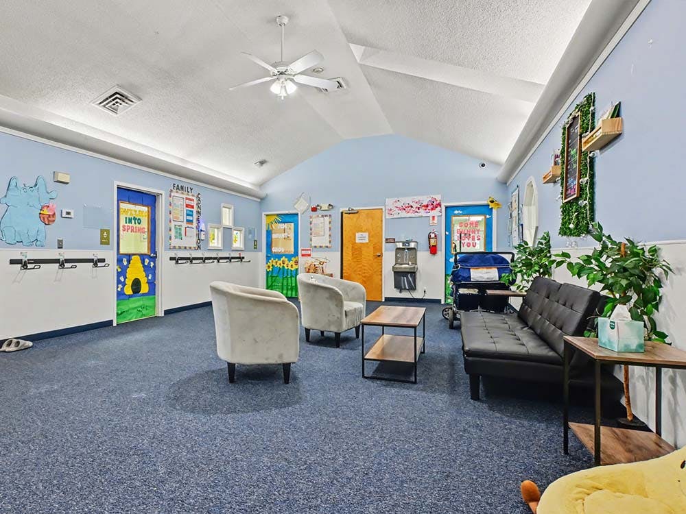 Lobby with a couch, chairs, tables, and decorated doors