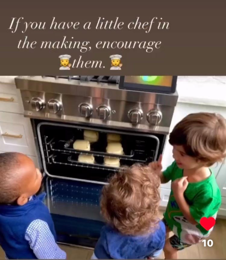 Three children looking into an oven with food inside