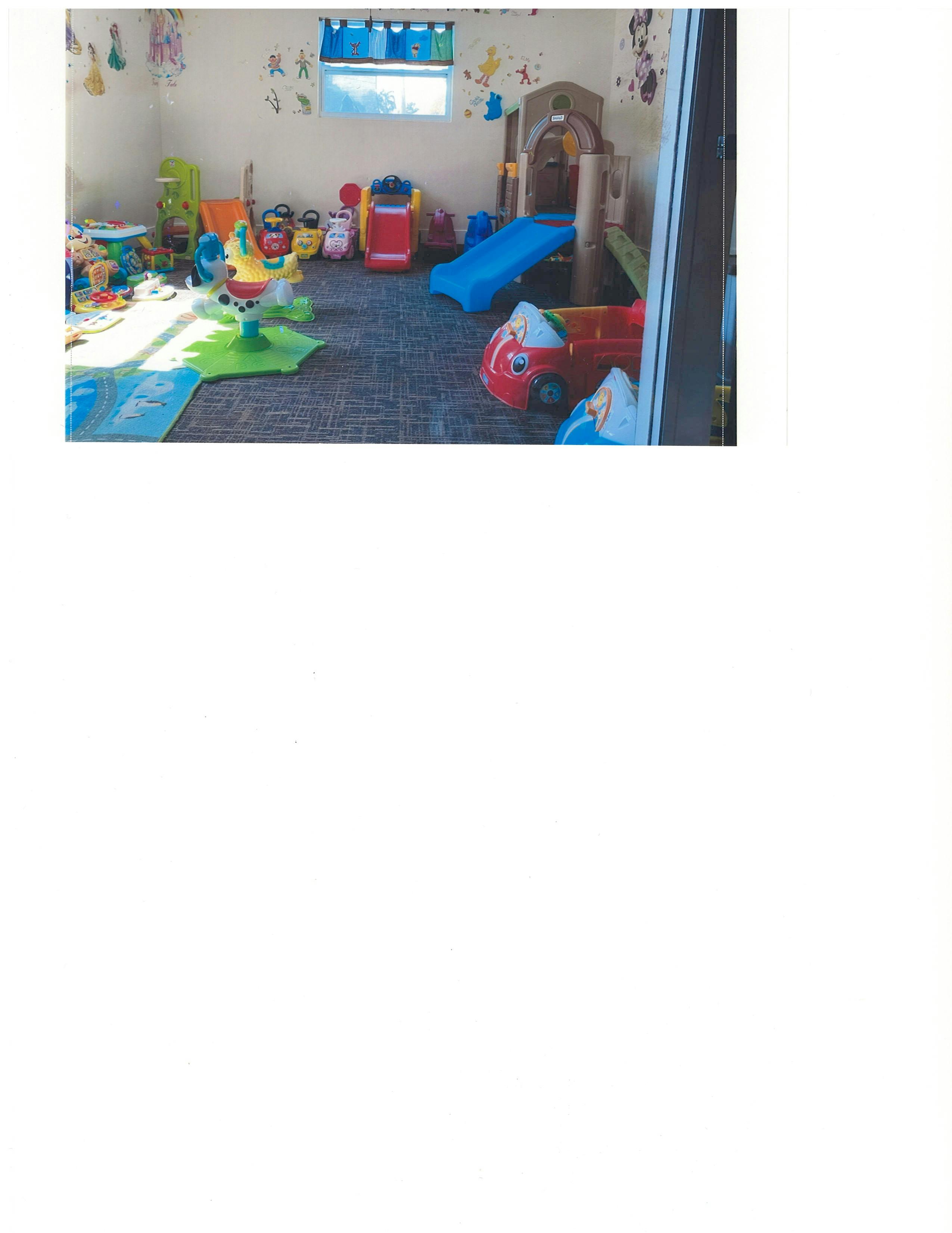 Playroom with various colorful toys, including a slide and ride-on car