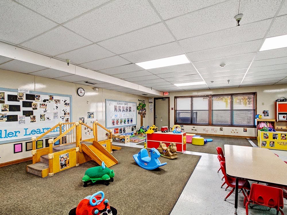 children's play area with slides, rocking toys, and tables