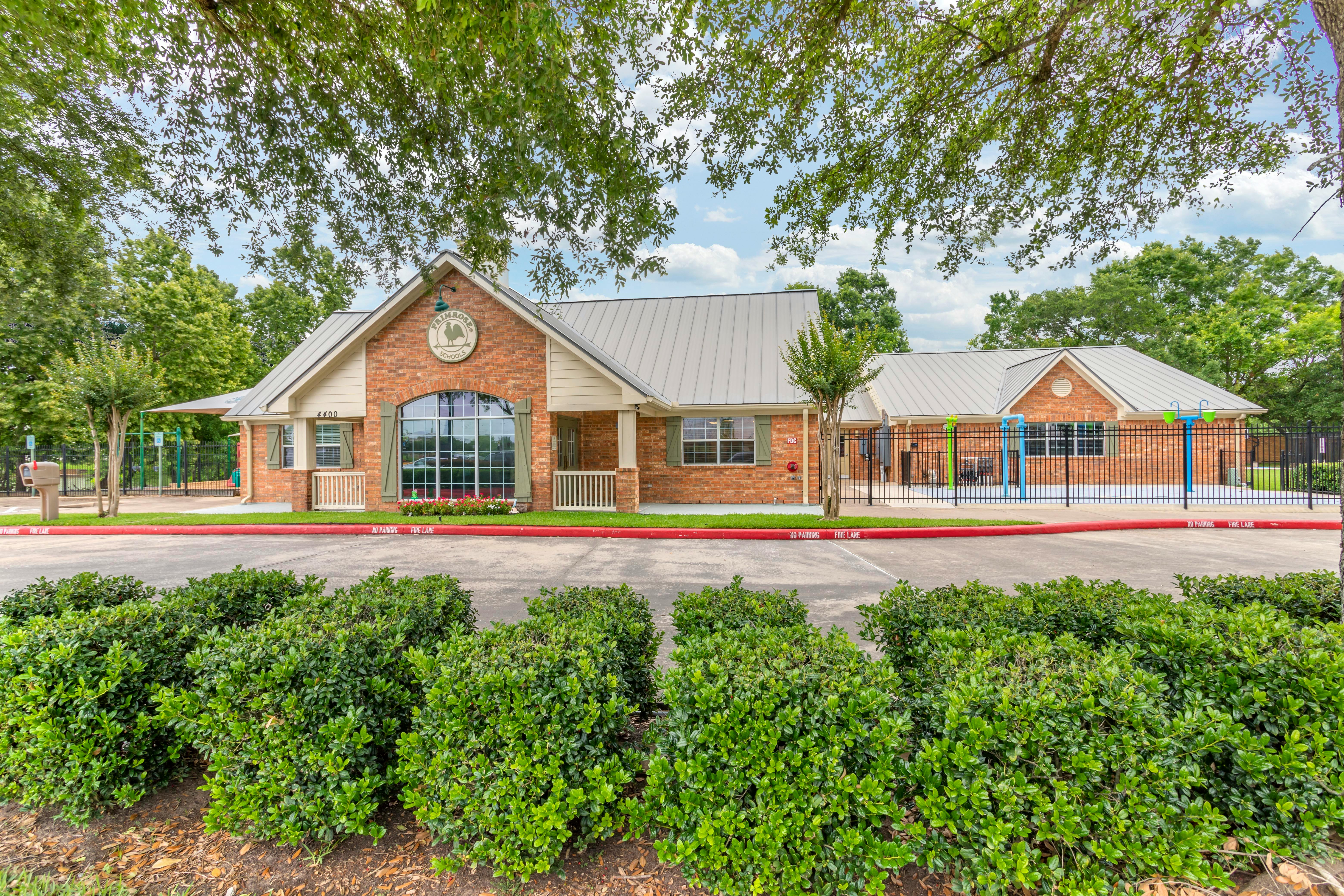 Brick school building with gray roof and red fire lane in front