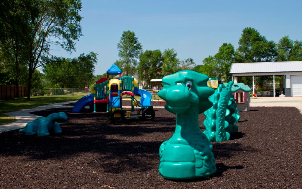 Playground with colorful play structure and green dragon-shaped equipment