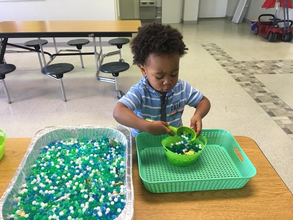 Child playing with beads and scoops