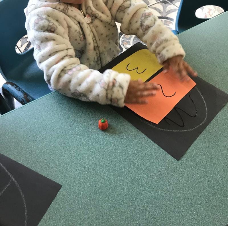 Child's hands on paper with drawn shapes