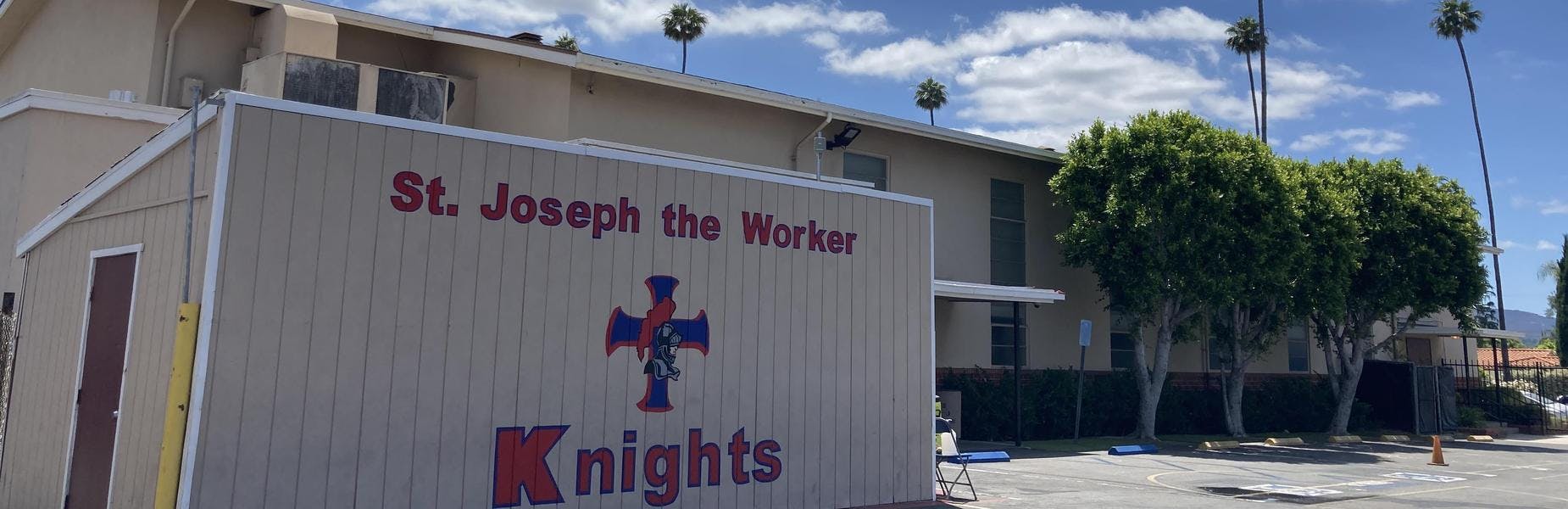 Sign for St. Joseph the Worker Knights next to a building and trees
