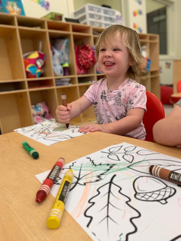 Child coloring a picture at a table
