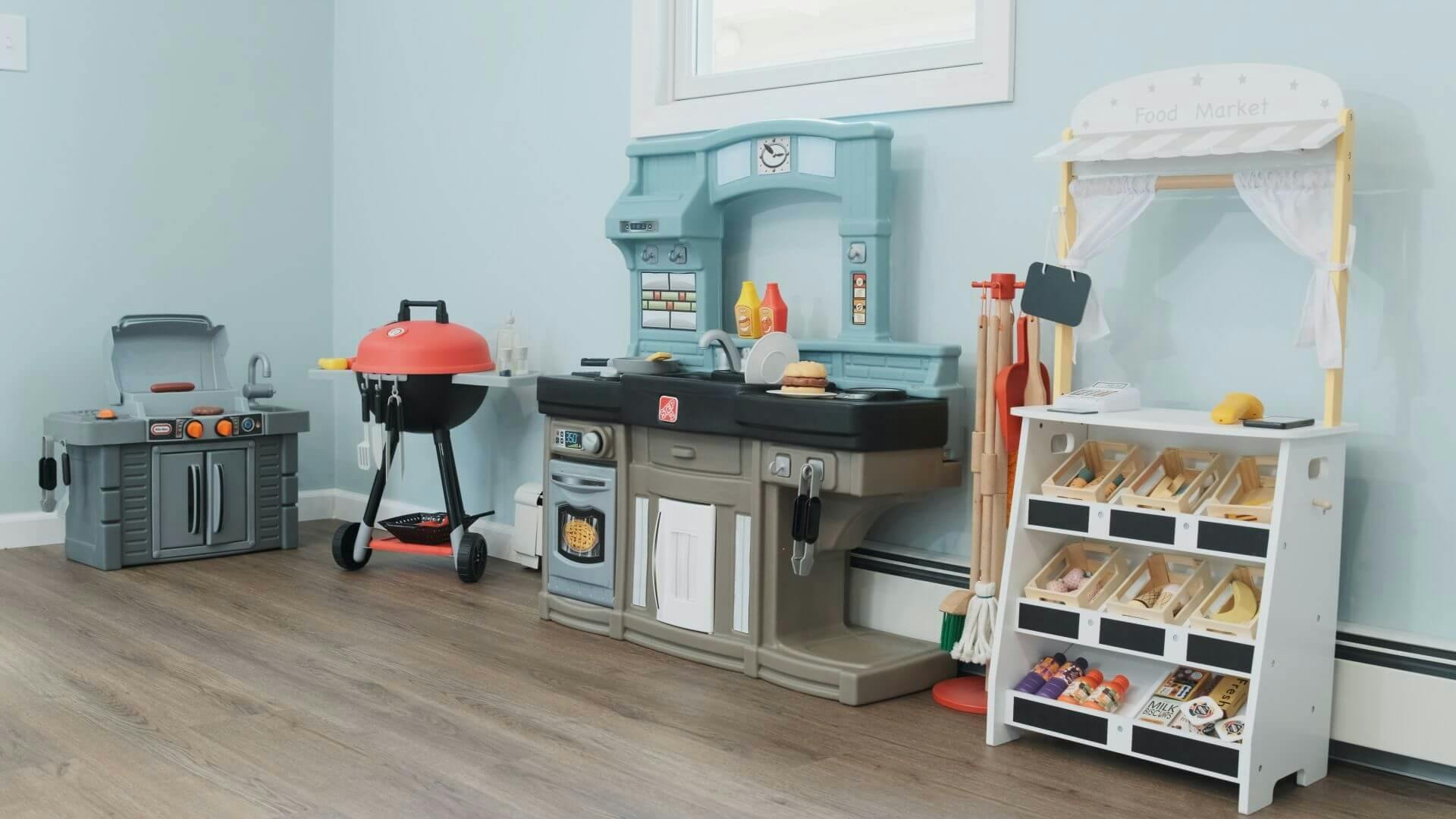 Play kitchen and food market toys in a room