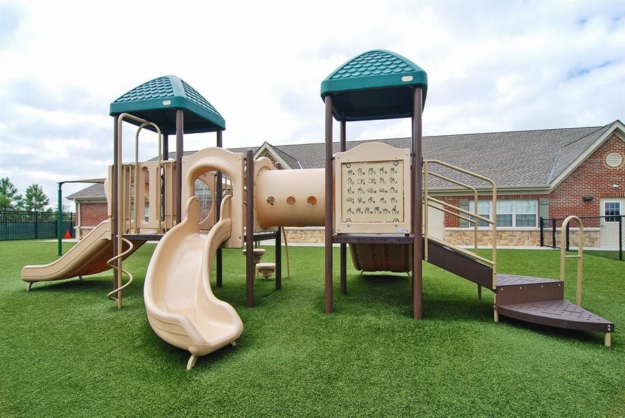 Playground with slides, tunnels, and stairs on green turf