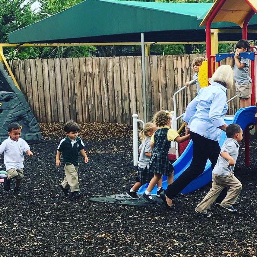 Adult and children playing on a playground