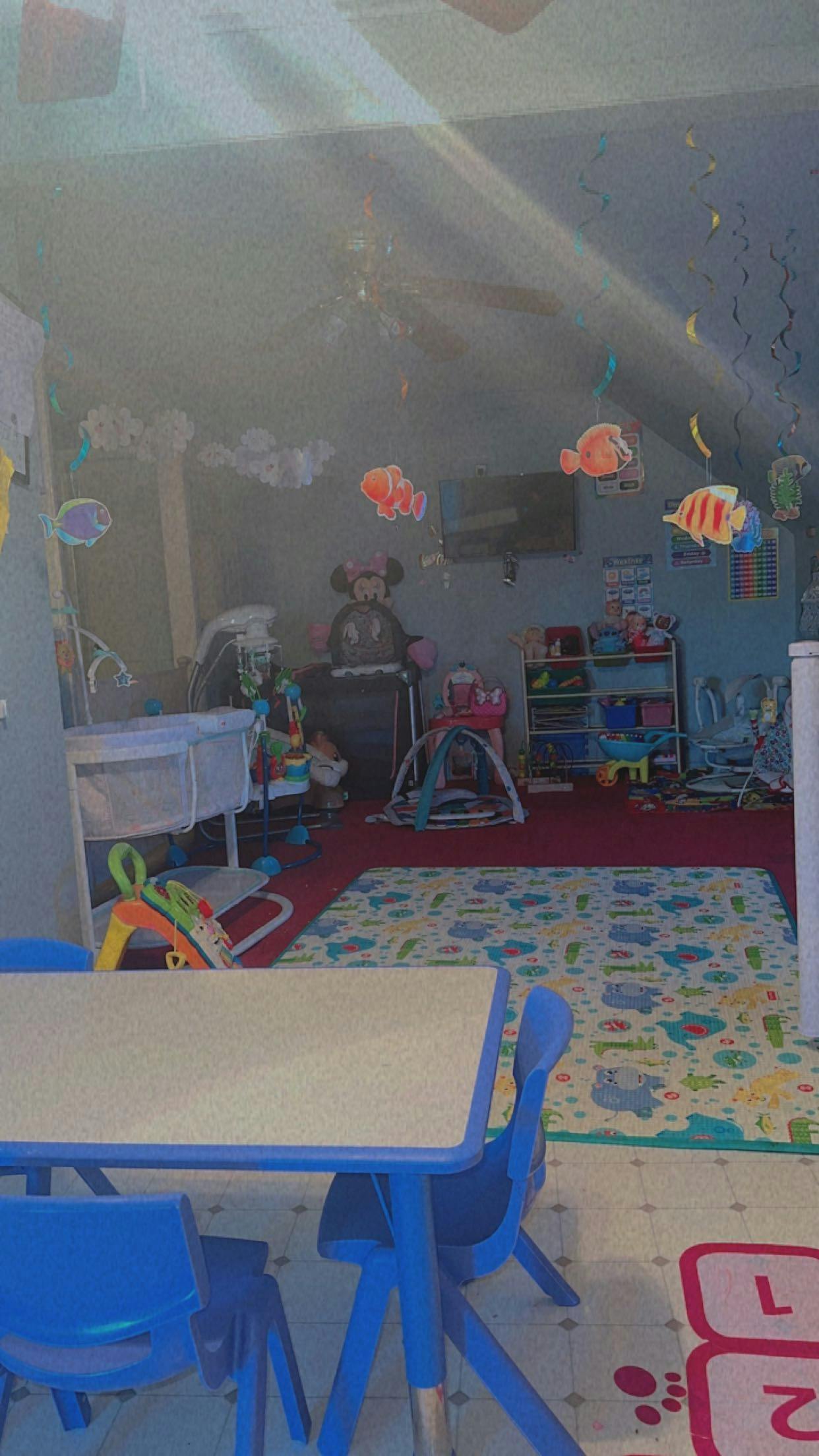 Playroom with small table and chairs, crib, and toys