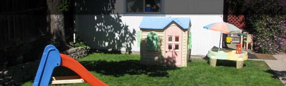 Playground with a slide, playhouse, and sand table
