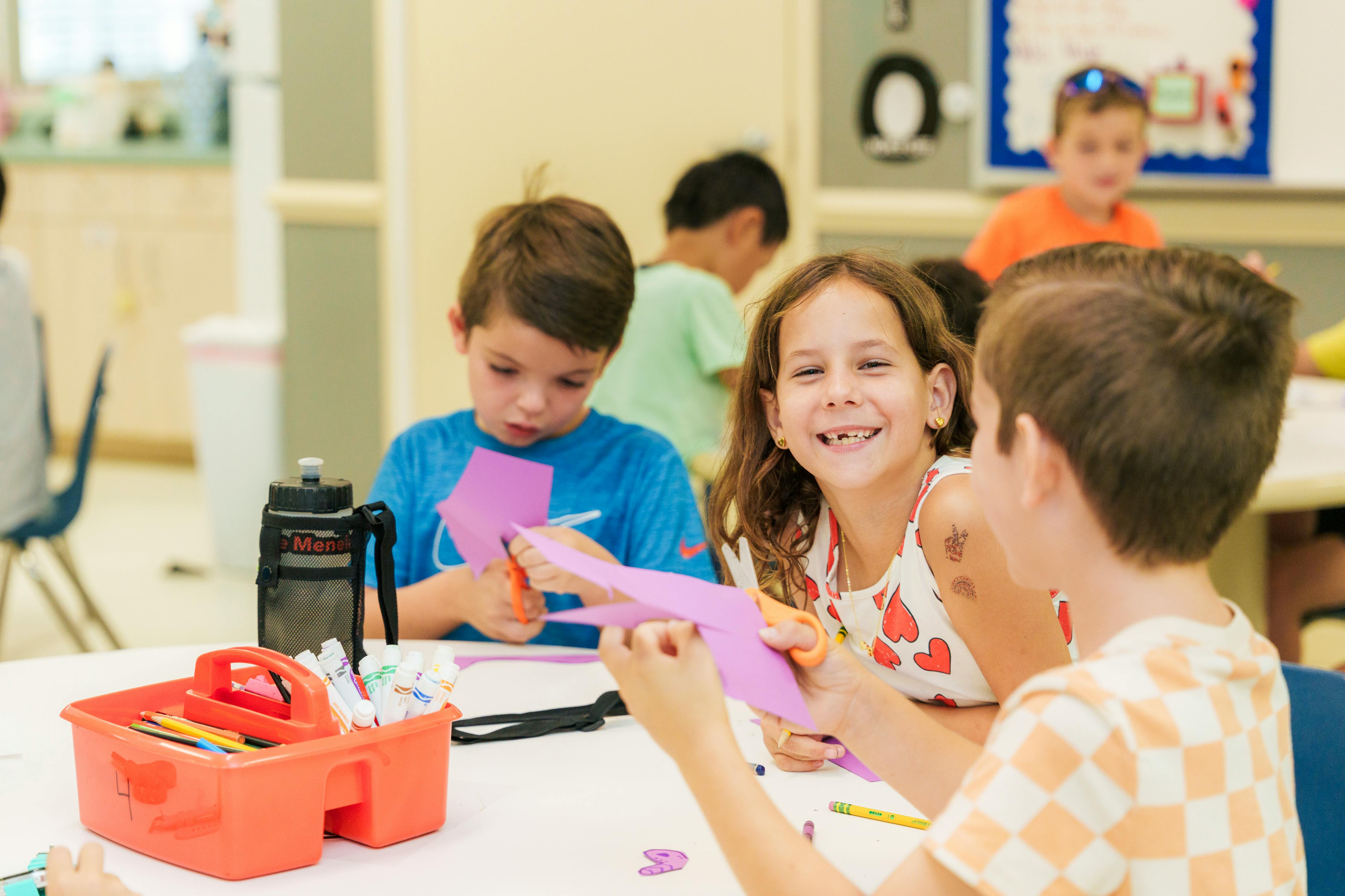 Children cutting paper at a table