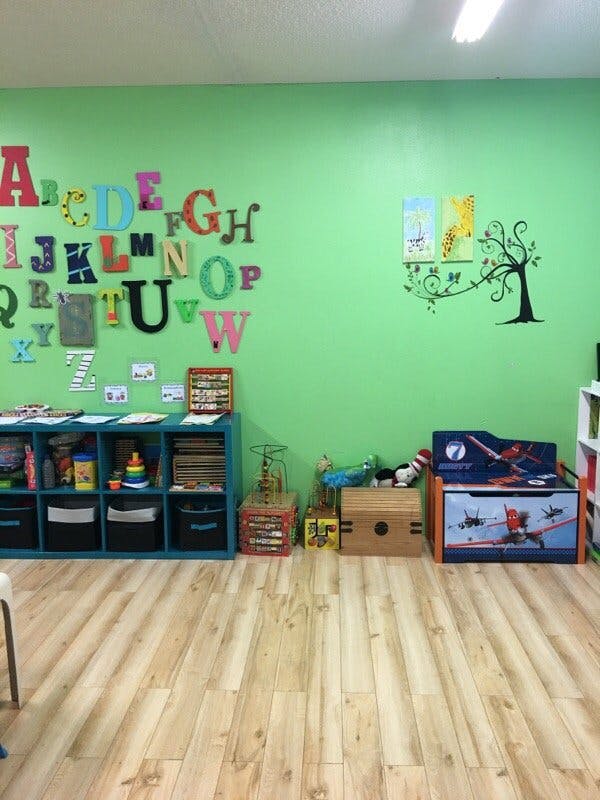 Classroom with alphabet letters on a green wall and storage shelves