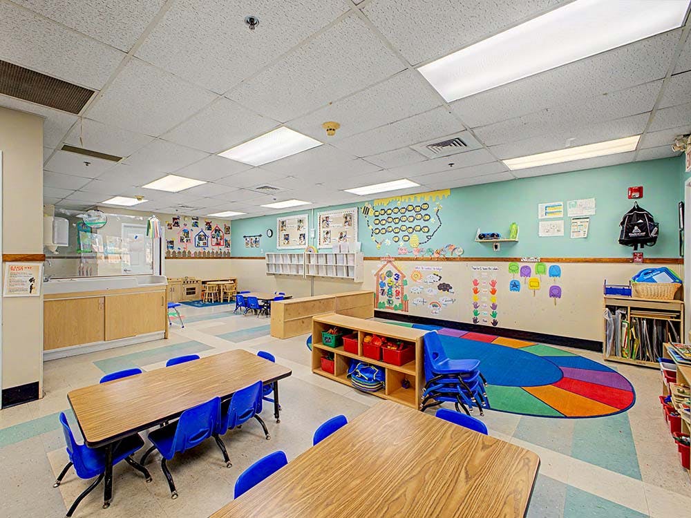 Classroom with tables, chairs, and colorful decorations on the walls