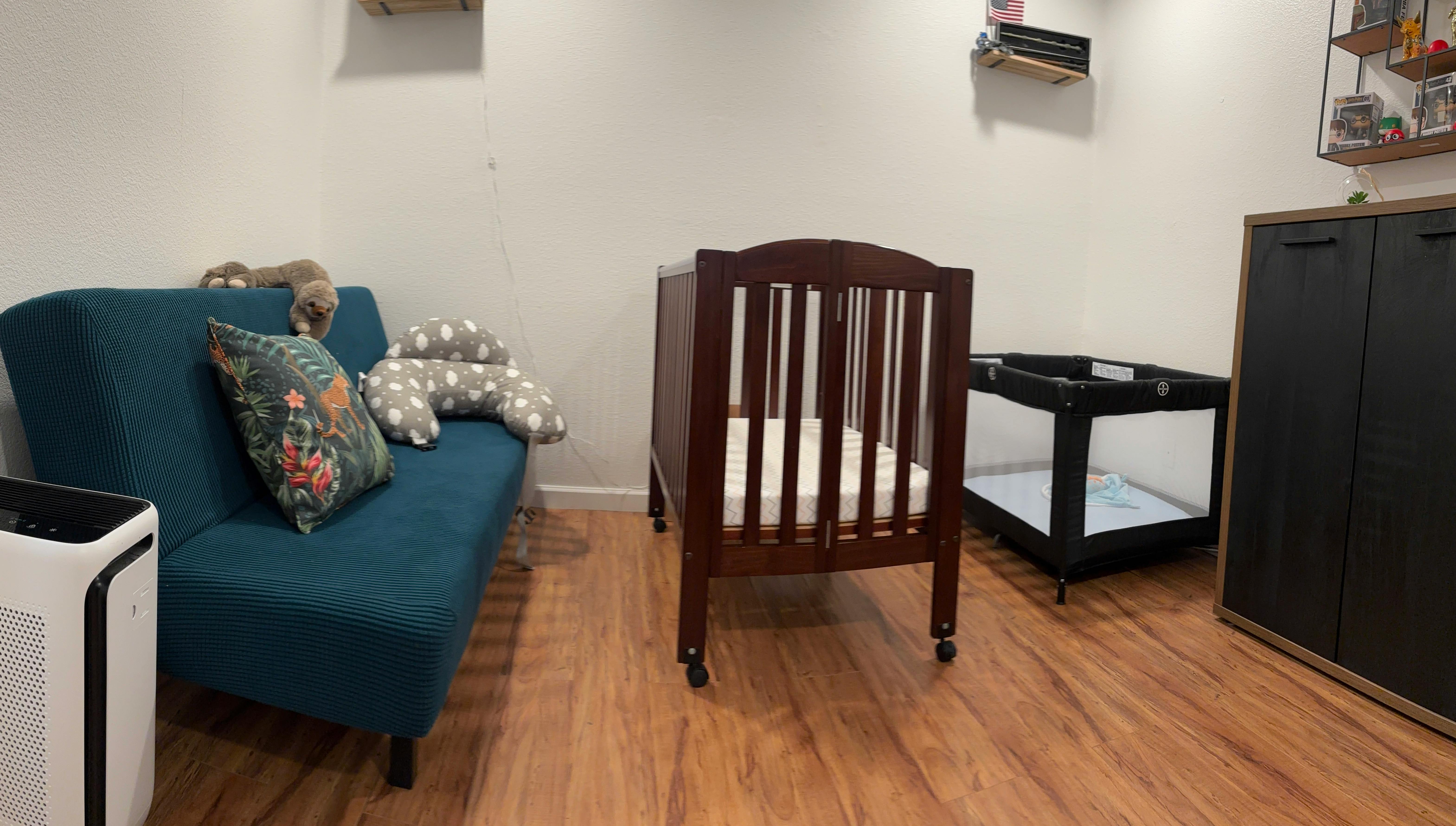 Crib, playpen, and sofa in a room