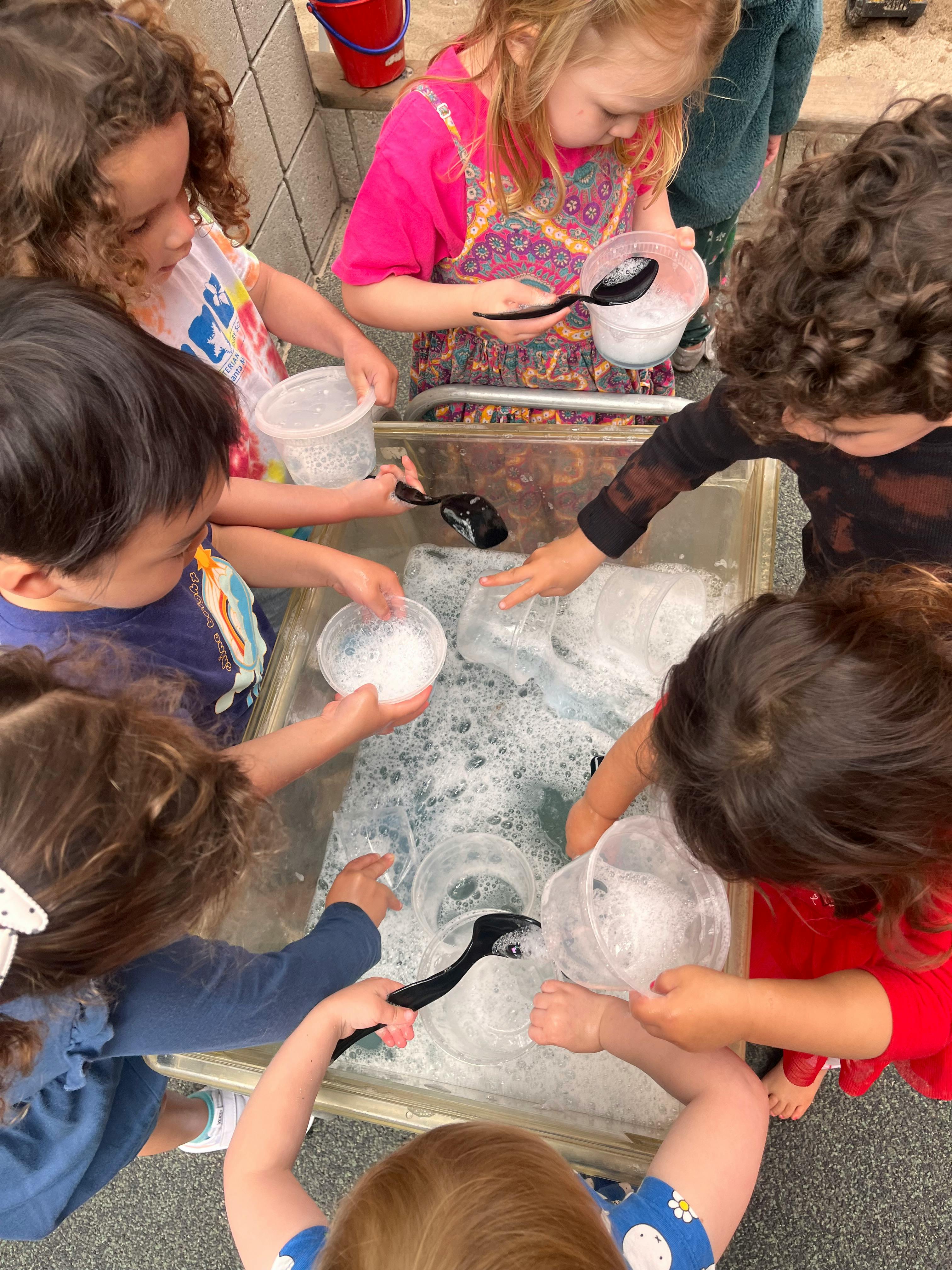 Children playing with water and bubbles in a sensory bin
