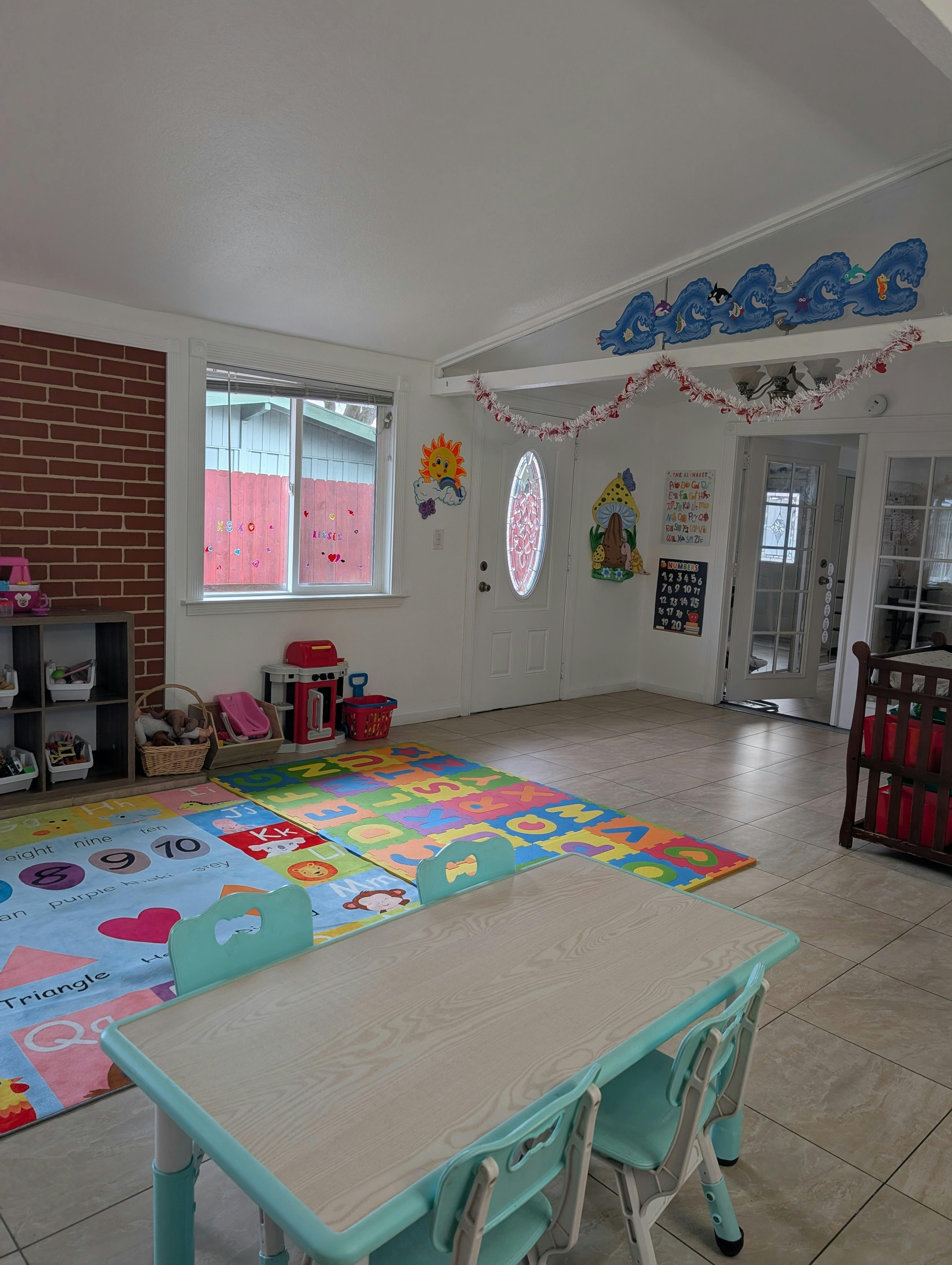 Children's play area with an alphabet mat, small table, and toys