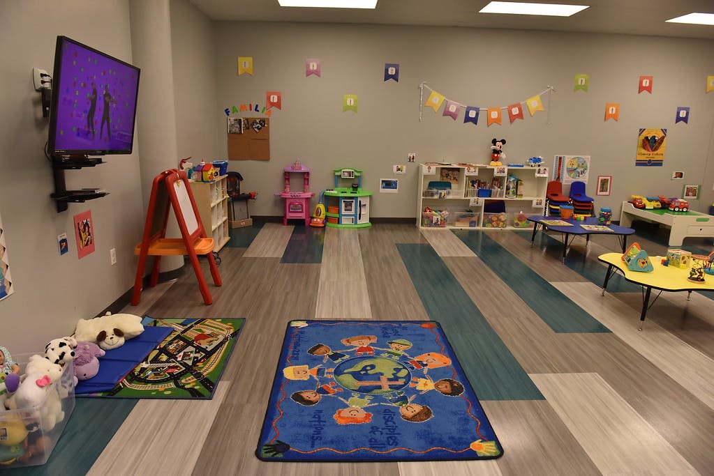 Playroom with toys, tables, and a television