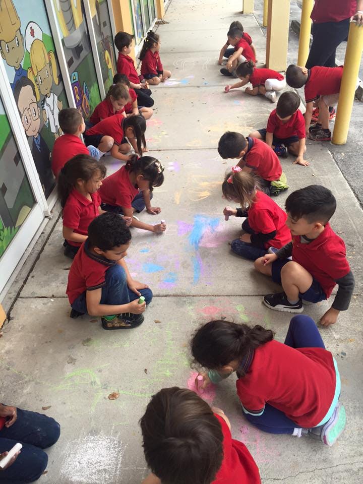 Children drawing with chalk on a sidewalk