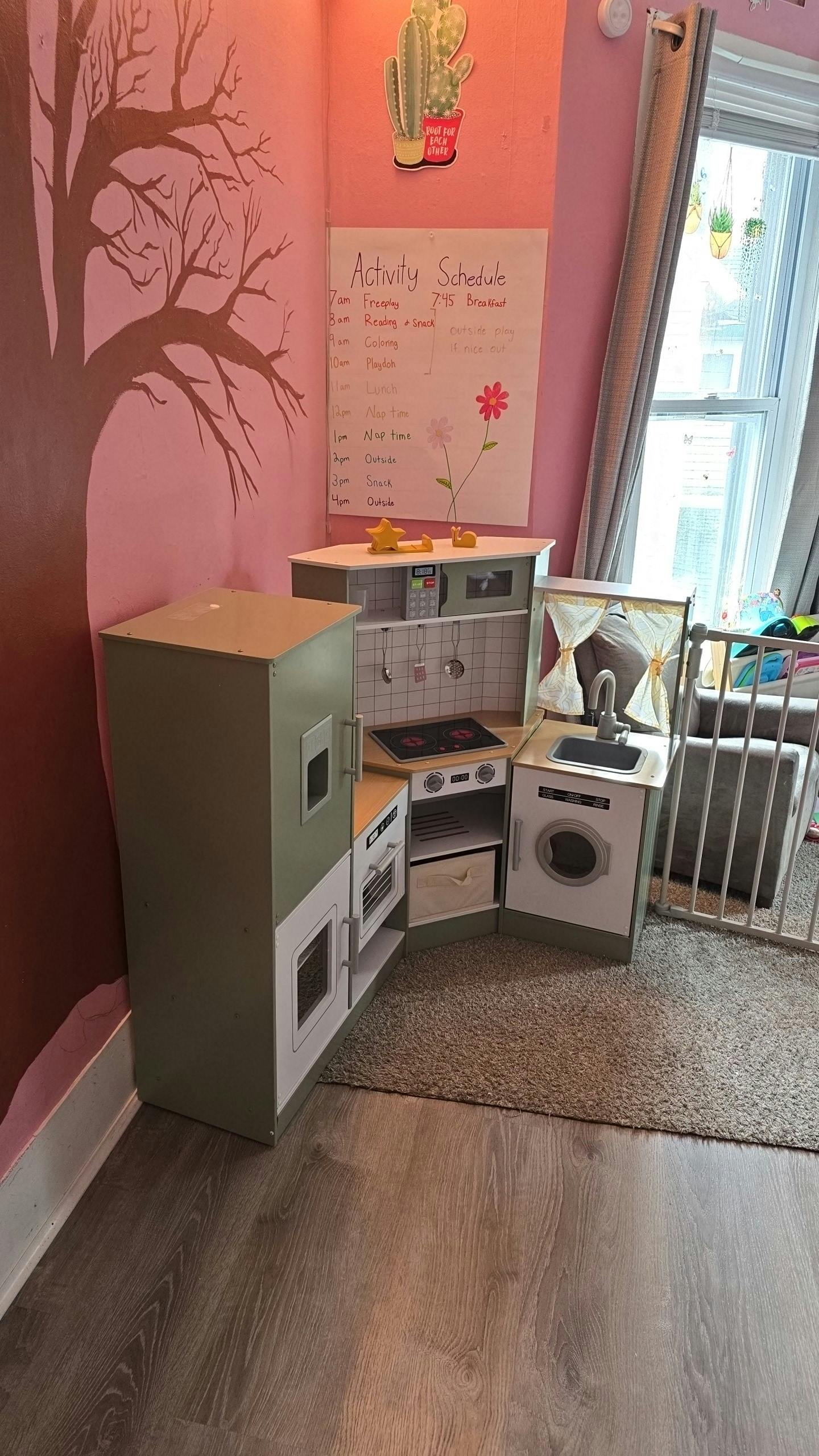 Child's play kitchen set with refrigerator, stove, sink, and washing machine