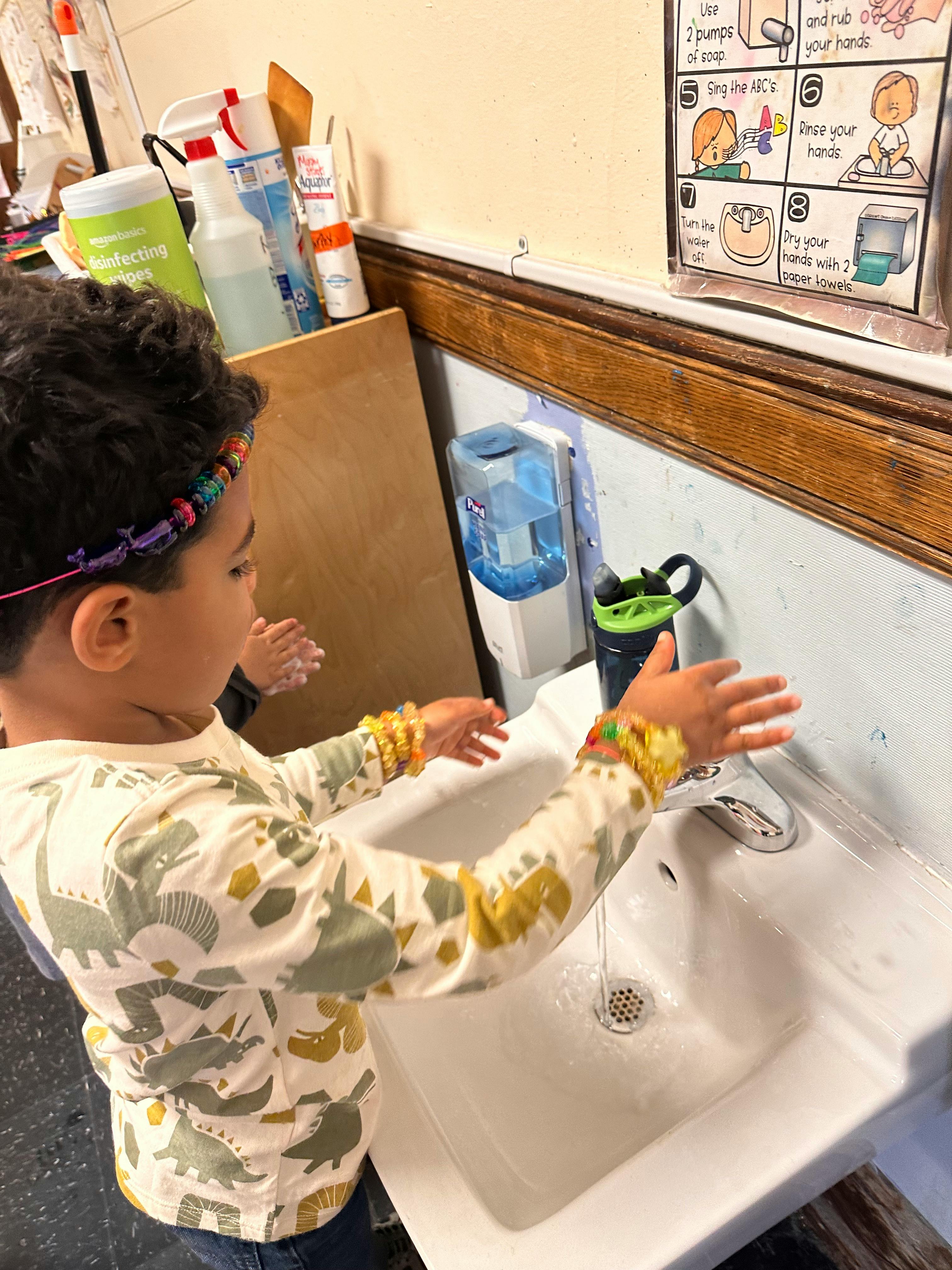 Child washing hands at a sink