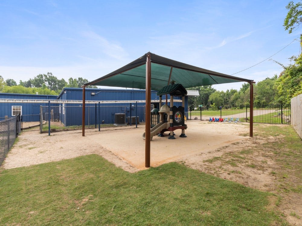 Playground area with a slide and a shade structure