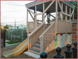 Wooden playground structure with stairs and a slide