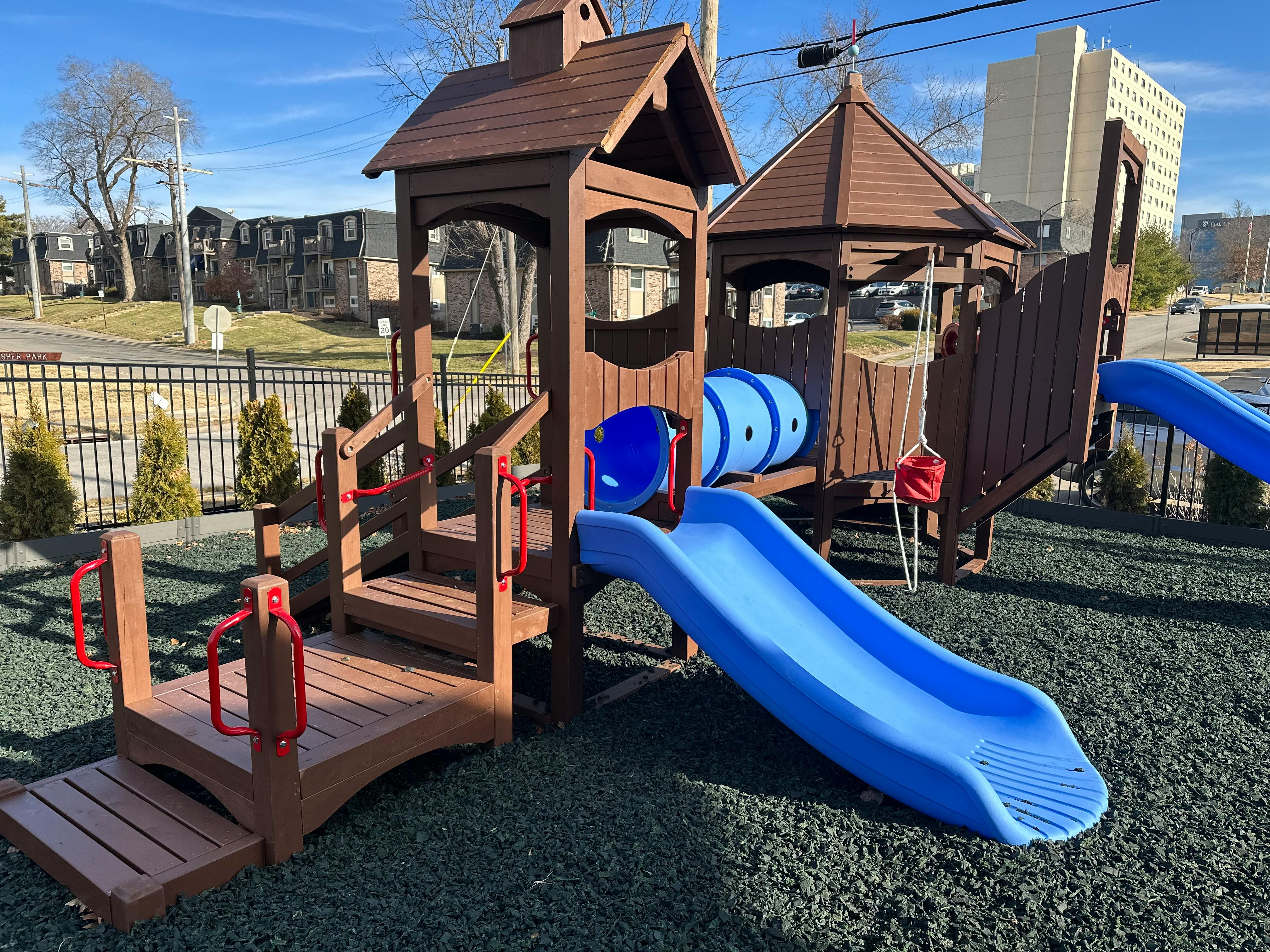 Playground with blue slides and brown wooden structures