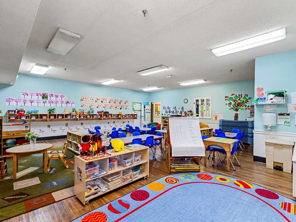 Empty colorful children's classroom with small tables and chairs