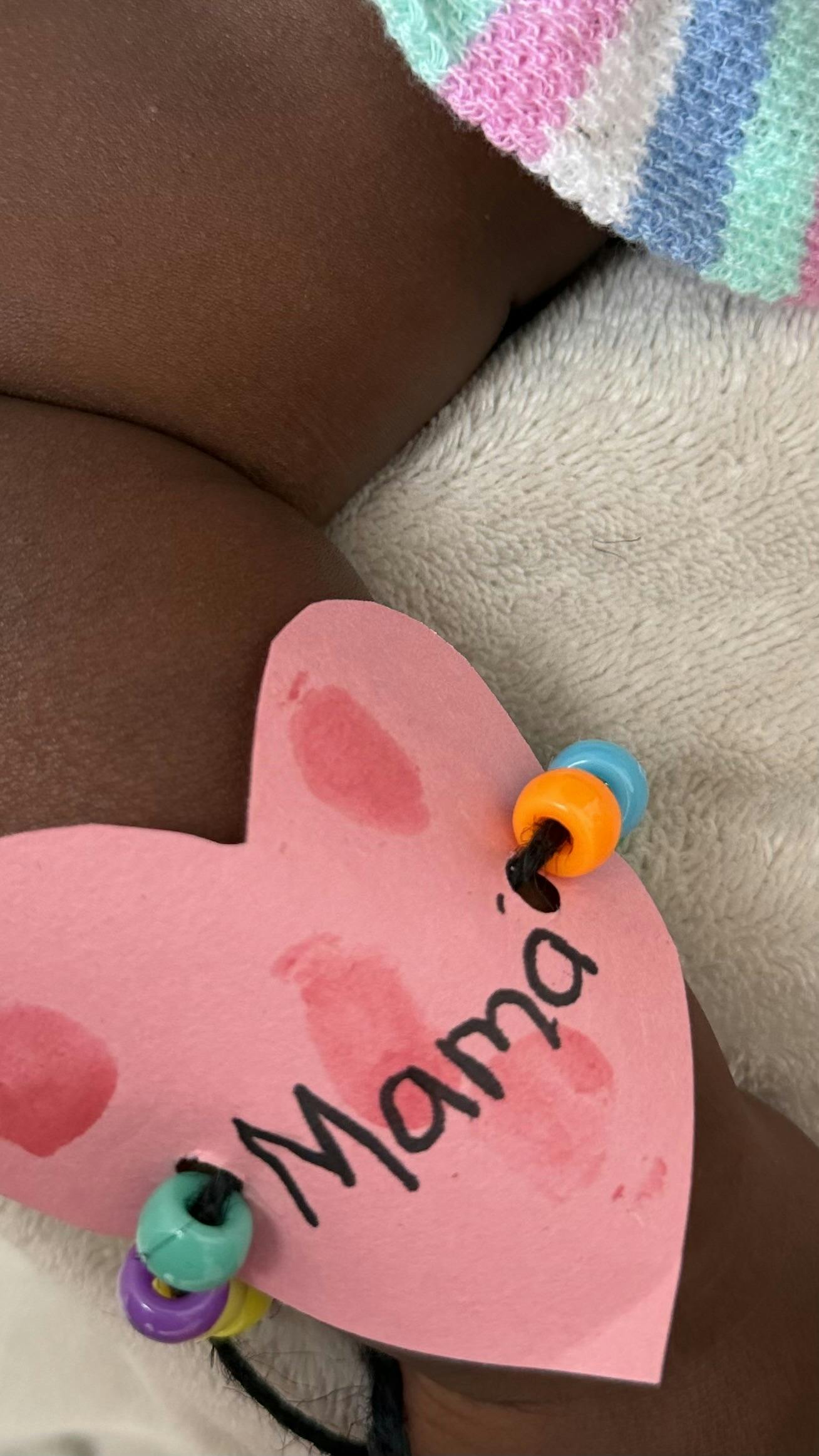Pink heart-shaped craft with colorful beads and the word "Mama"