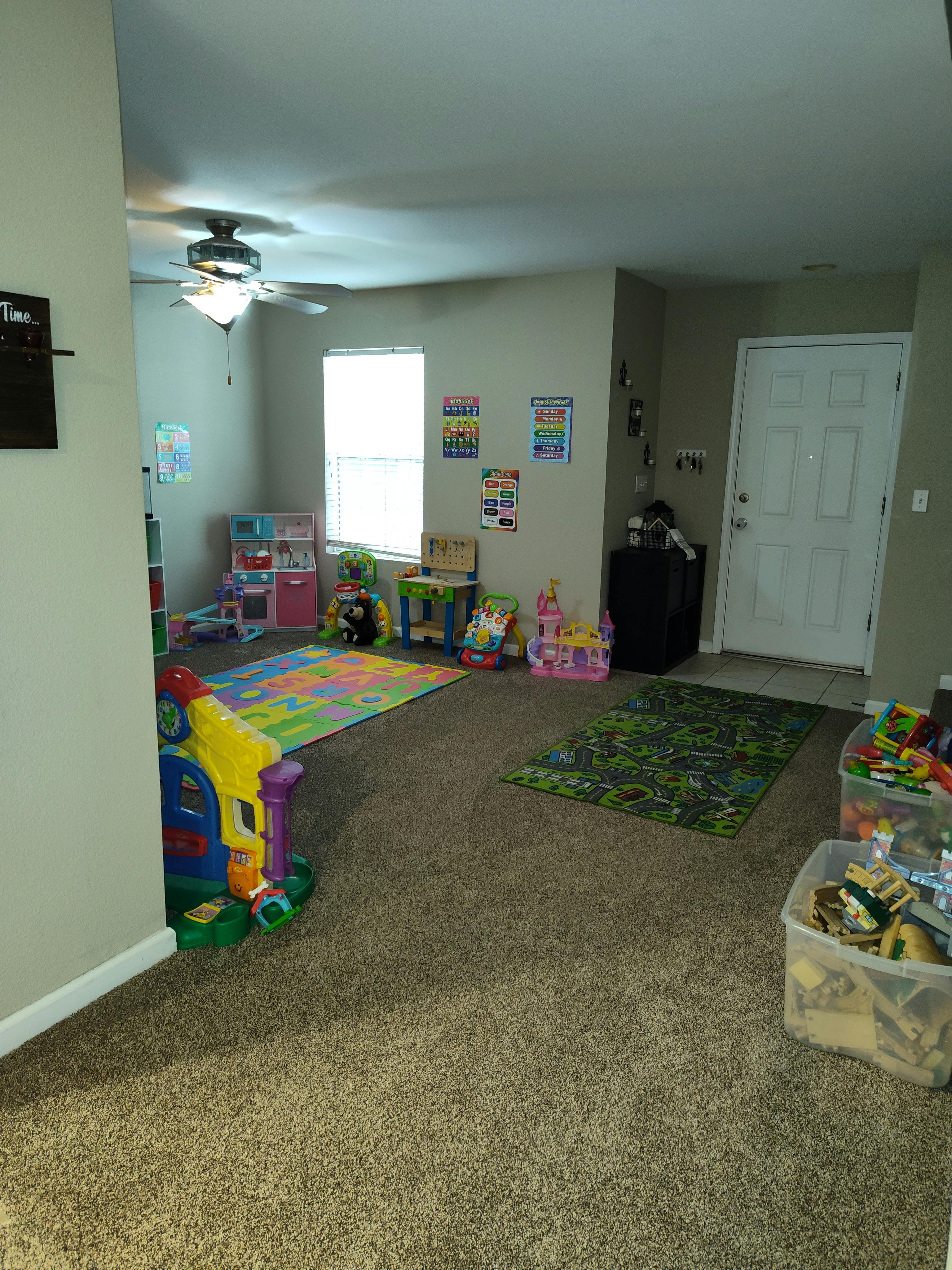 Playroom with colorful rugs and various toys