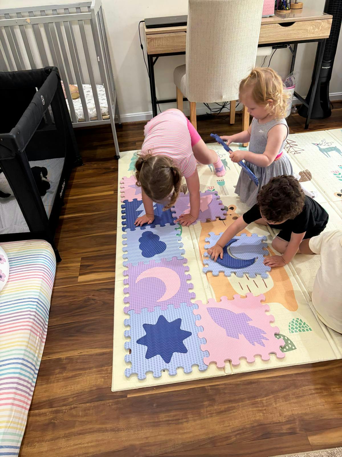 Children playing with foam puzzle mats on the floor