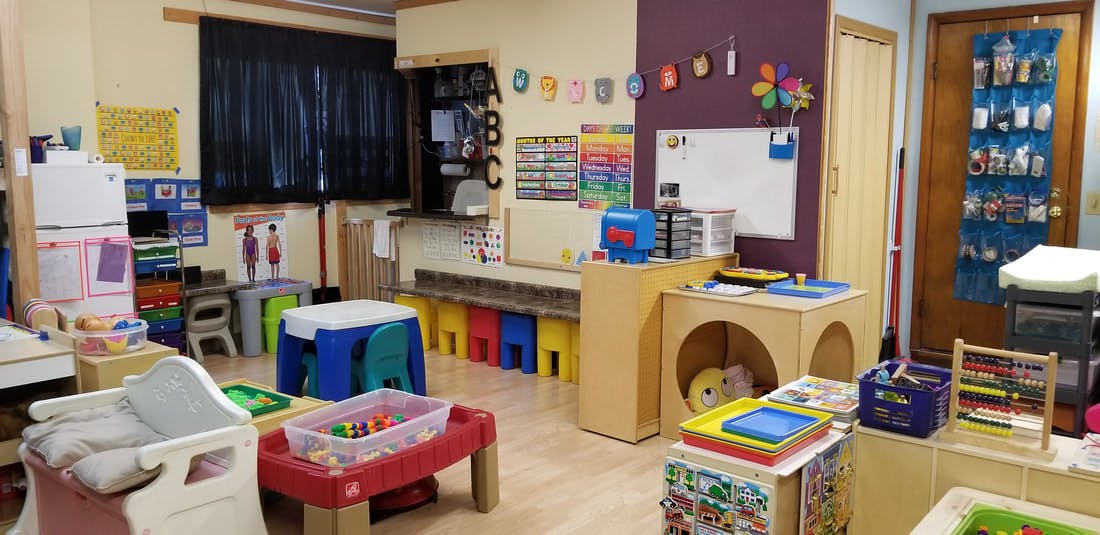 A classroom with small tables and chairs, toys, and learning materials