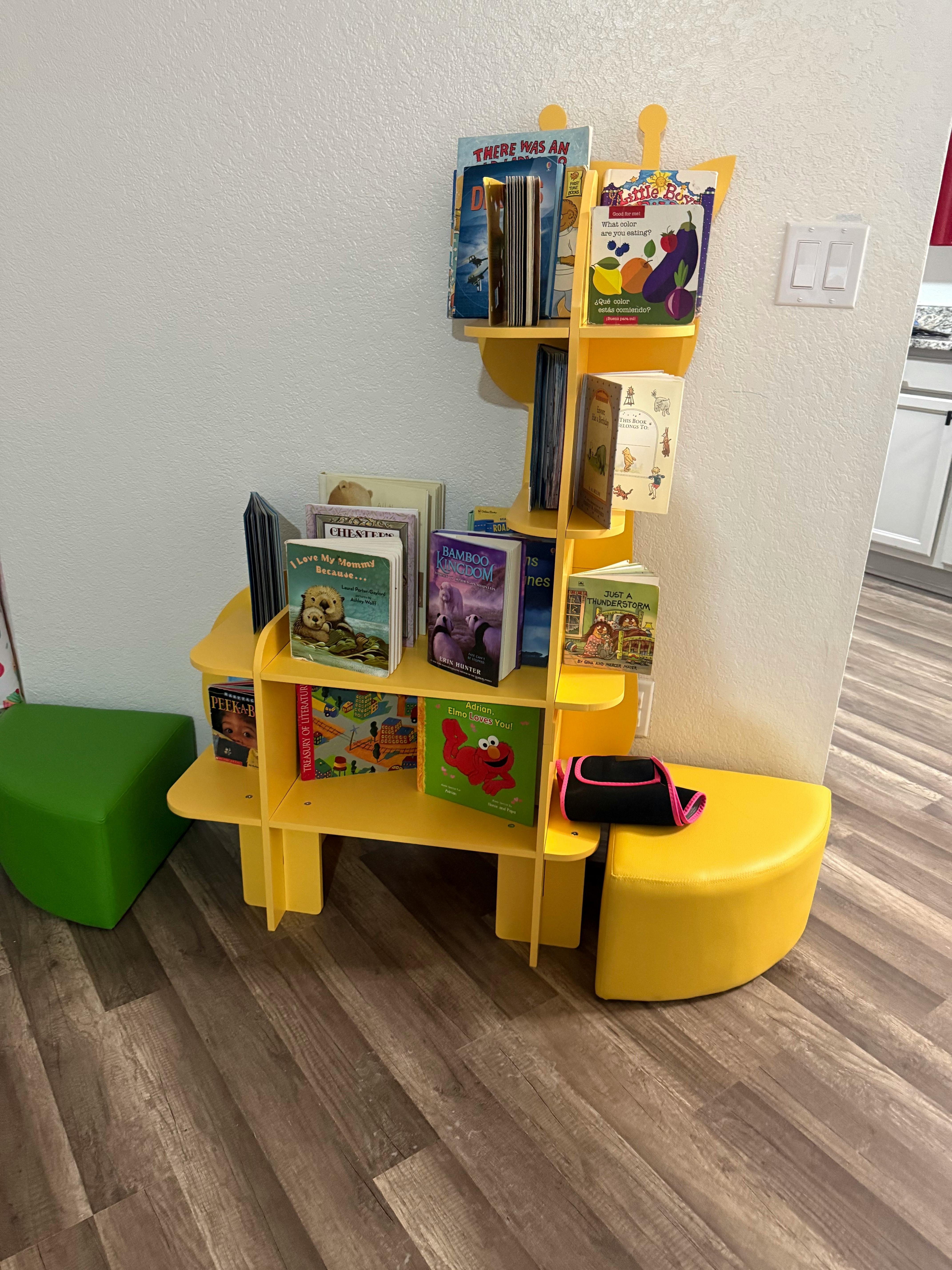 Yellow bookshelf with books and a green ottoman