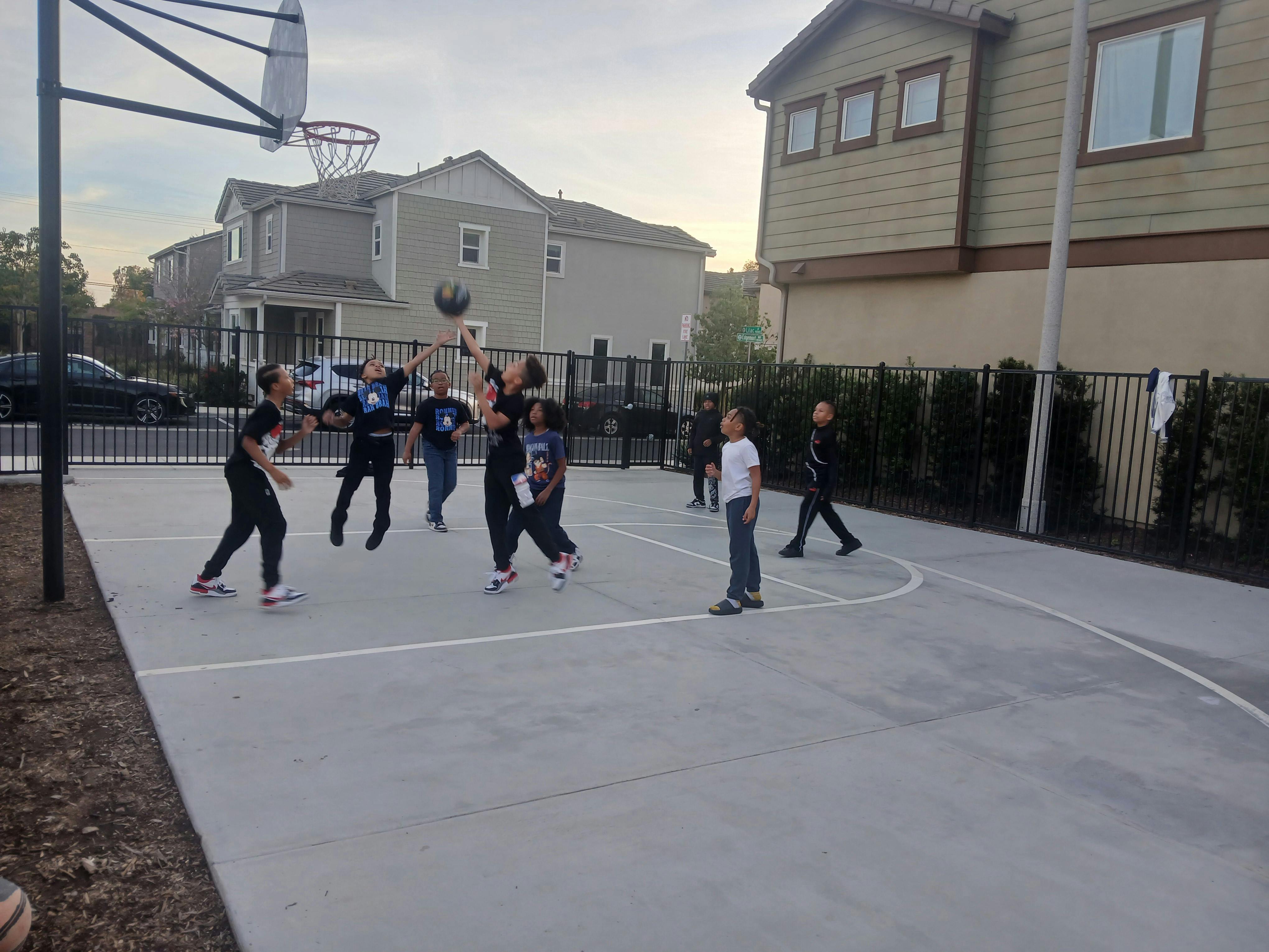 People playing basketball on an outdoor court